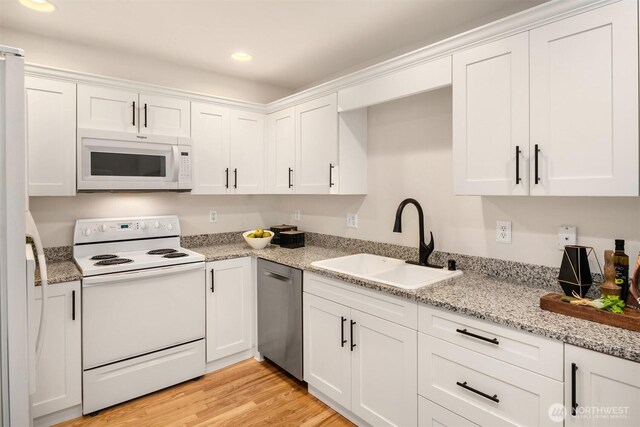 17515 110th Ln SE Unit 27, Renton, WA 98055 - kitchen with white appliances, white cabinets, recessed lighting, light wood-type flooring, and light stone countertops