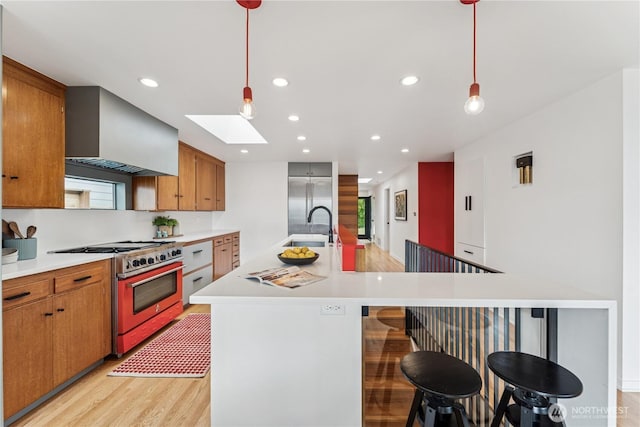 2626 W Lynn St, Seattle, WA 98199 - kitchen with high end appliances, a skylight, light wood-style flooring, light countertops, and recessed lighting