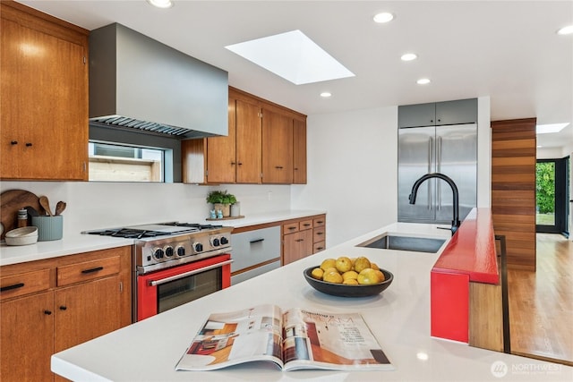 2626 W Lynn St, Seattle, WA 98199 - kitchen with stainless steel range, a skylight, light countertops, custom range hood, and recessed lighting