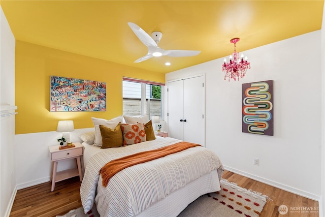 2626 W Lynn St, Seattle, WA 98199 - bedroom with wood finished floors, a closet, a ceiling fan, and a chandelier