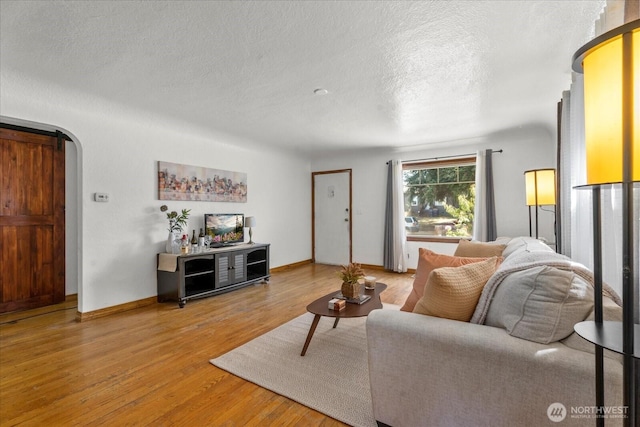 7012 S Warner St, Tacoma, WA 98409 - living area featuring wood finished floors, a textured ceiling, and arched walkways
