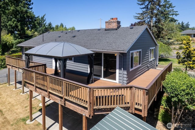 10414 43rd Street Ct E, Edgewood, WA 98372 - back of property with a wooden deck, a shingled roof, and a chimney