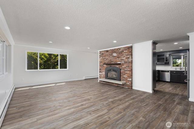 10414 43rd Street Ct E, Edgewood, WA 98372 - unfurnished living room featuring a baseboard radiator, a textured ceiling, wood finished floors, recessed lighting, and a fireplace