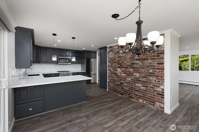 10414 43rd Street Ct E, Edgewood, WA 98372 - kitchen featuring stainless steel appliances, a chandelier, a peninsula, dark wood-style floors, and crown molding