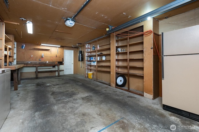 10414 43rd Street Ct E, Edgewood, WA 98372 - garage with freestanding refrigerator, a garage door opener, and a workshop area