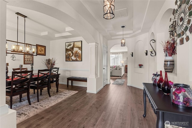 22817 80th Avenue Ct E, Graham, WA 98338 - dining space with a tray ceiling, dark wood finished floors, arched walkways, and a chandelier