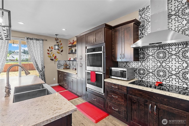 22817 80th Avenue Ct E, Graham, WA 98338 - kitchen with appliances with stainless steel finishes, wall chimney range hood, light wood-style floors, light countertops, and dark brown cabinetry