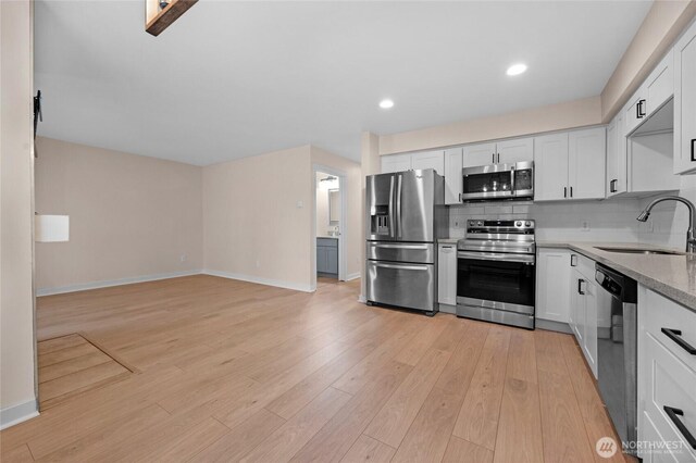 12303 Harbour Pointe Blvd Unit S104, Mukilteo, WA 98275 - kitchen featuring stainless steel appliances, light wood-type flooring, white cabinets, backsplash, and recessed lighting