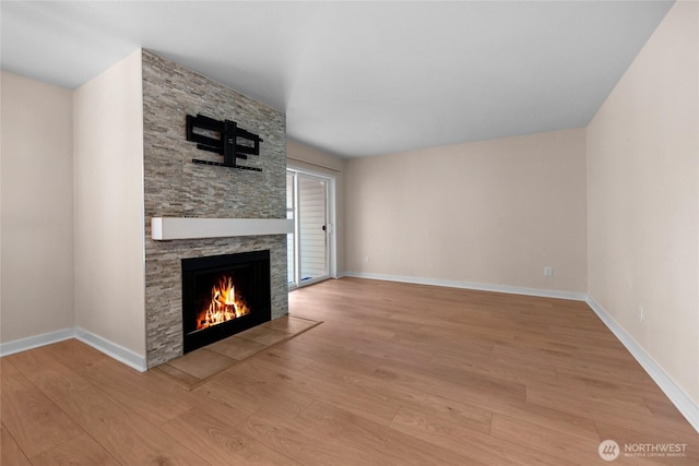 12303 Harbour Pointe Blvd Unit S104, Mukilteo, WA 98275 - unfurnished living room featuring a stone fireplace and light wood-type flooring