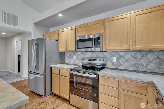 18619 16th Avenue Ct E, Spanaway, WA 98387 - kitchen featuring appliances with stainless steel finishes, light brown cabinetry, light countertops, light wood-type flooring, and decorative backsplash