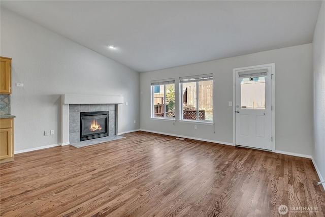 18619 16th Avenue Ct E, Spanaway, WA 98387 - unfurnished living room featuring lofted ceiling, a tile fireplace, and wood finished floors