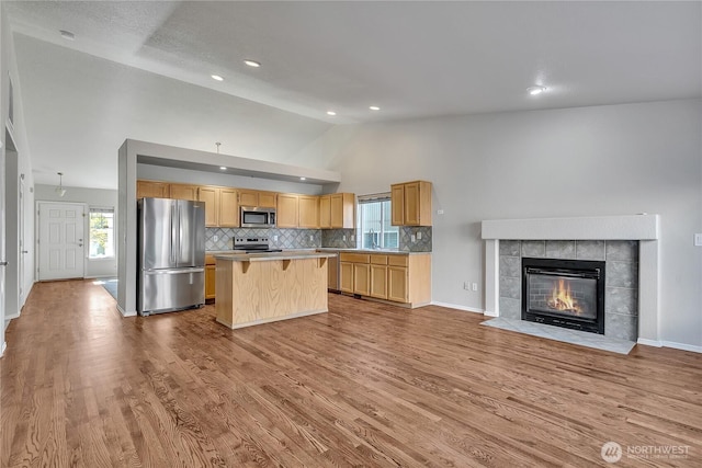 18619 16th Avenue Ct E, Spanaway, WA 98387 - kitchen with appliances with stainless steel finishes, a kitchen island, light countertops, light brown cabinetry, and open floor plan