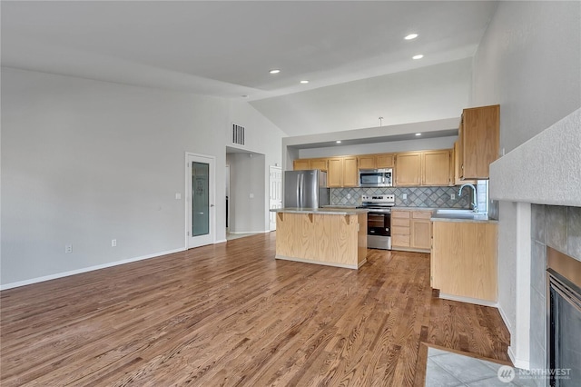 18619 16th Avenue Ct E, Spanaway, WA 98387 - kitchen with stainless steel appliances, a center island, light brown cabinetry, light countertops, and light wood finished floors