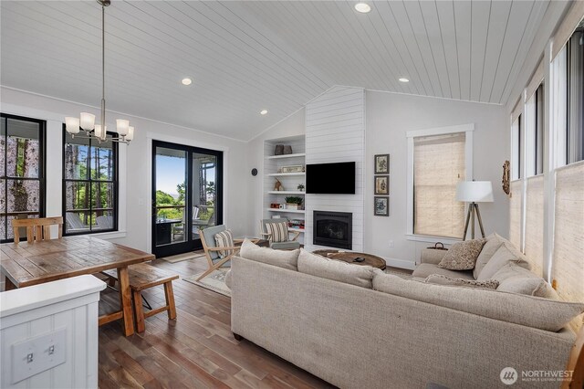 46 Seaside Ln, Pacific Beach, WA 98571 - living area featuring vaulted ceiling, dark wood-type flooring, a chandelier, a fireplace, and built in shelves