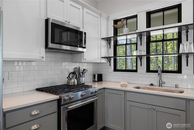 46 Seaside Ln, Pacific Beach, WA 98571 - kitchen with stainless steel appliances, open shelves, gray cabinets, and tasteful backsplash