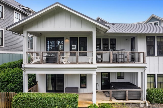 46 Seaside Ln, Pacific Beach, WA 98571 - back of property featuring a balcony, a covered hot tub, board and batten siding, and a metal roof