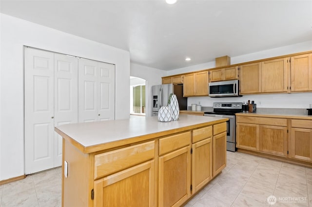 21012 82nd St E, Bonney Lake, WA 98391 - kitchen with stainless steel appliances, arched walkways, light countertops, recessed lighting, and a kitchen island
