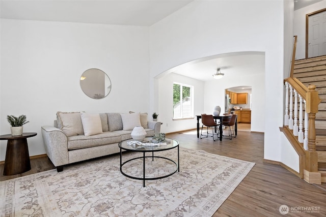 21012 82nd St E, Bonney Lake, WA 98391 - living room with arched walkways, stairs, wood finished floors, and a towering ceiling