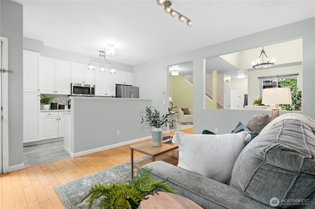 15150 140th Way SE Unit K103, Renton, WA 98058 - living room with a chandelier, light wood-style flooring, and stairway