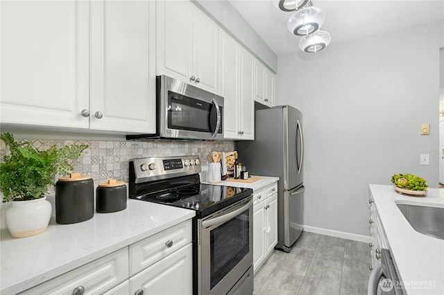 15150 140th Way SE Unit K103, Renton, WA 98058 - kitchen with stainless steel appliances, tasteful backsplash, white cabinetry, light stone counters, and light tile patterned flooring