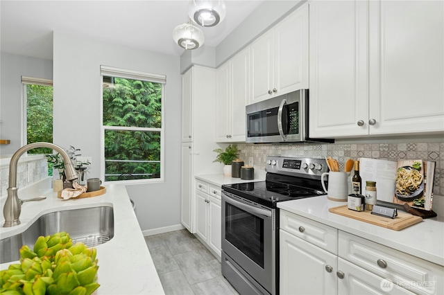 15150 140th Way SE Unit K103, Renton, WA 98058 - kitchen featuring appliances with stainless steel finishes, backsplash, light countertops, and white cabinetry