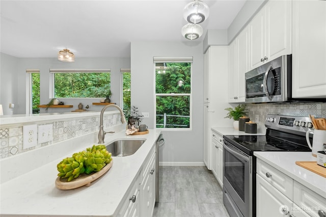 15150 140th Way SE Unit K103, Renton, WA 98058 - kitchen with appliances with stainless steel finishes, decorative backsplash, light countertops, and plenty of natural light