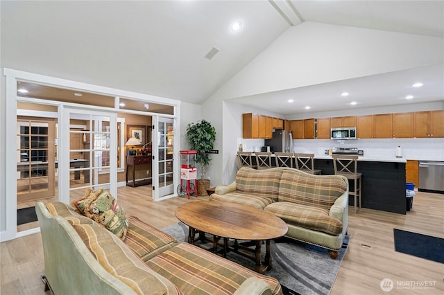 15150 140th Way SE Unit K103, Renton, WA 98058 - living room featuring french doors, high vaulted ceiling, light wood-type flooring, and recessed lighting