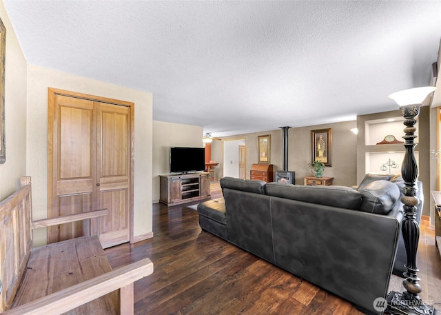 5215 Richmond Cres, Blaine, WA 98230 - living area with a wood stove, a textured ceiling, and dark wood finished floors