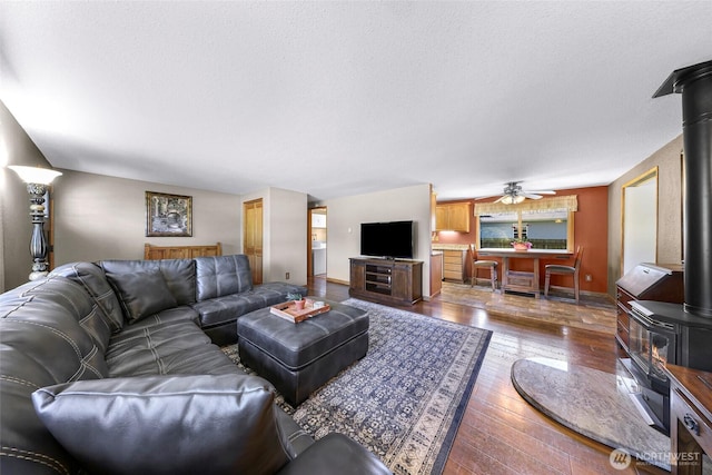 5215 Richmond Cres, Blaine, WA 98230 - living area with a wood stove, hardwood / wood-style flooring, a textured ceiling, and a ceiling fan