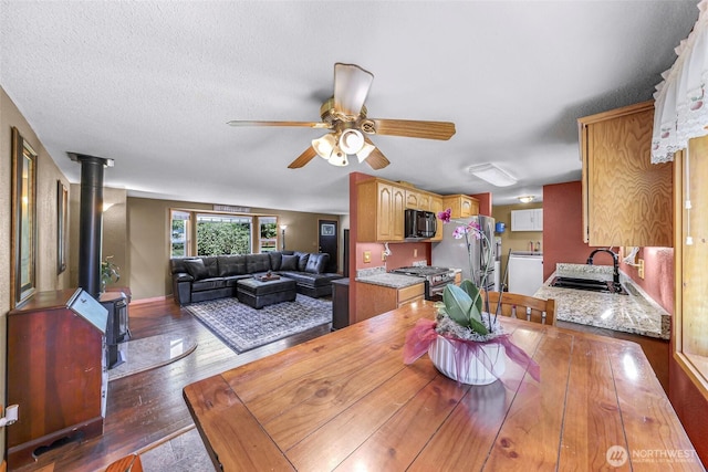 5215 Richmond Cres, Blaine, WA 98230 - dining room featuring a wood stove, ceiling fan, and dark wood-type flooring