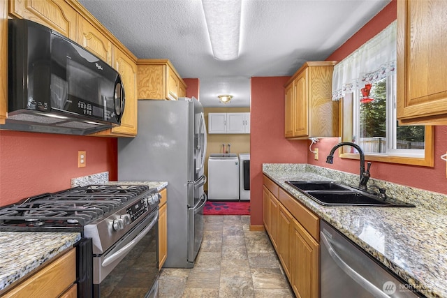 5215 Richmond Cres, Blaine, WA 98230 - kitchen with appliances with stainless steel finishes, independent washer and dryer, light stone finish floors, light stone counters, and a textured ceiling