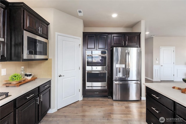 6639 S 298th Pl, Auburn, WA 98001 - kitchen with stainless steel appliances, light countertops, light wood finished floors, decorative backsplash, and recessed lighting