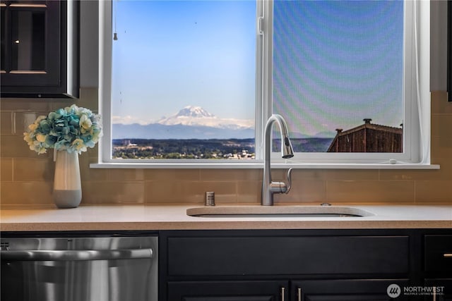 6639 S 298th Pl, Auburn, WA 98001 - kitchen view of stainless steel dishwasher, decorative backsplash, dark cabinetry, and light countertops