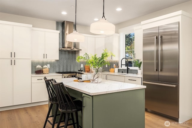 10511 NE 112th St, Kirkland, WA 98033 - kitchen featuring built in refrigerator, wall chimney range hood, backsplash, white cabinets, and recessed lighting
