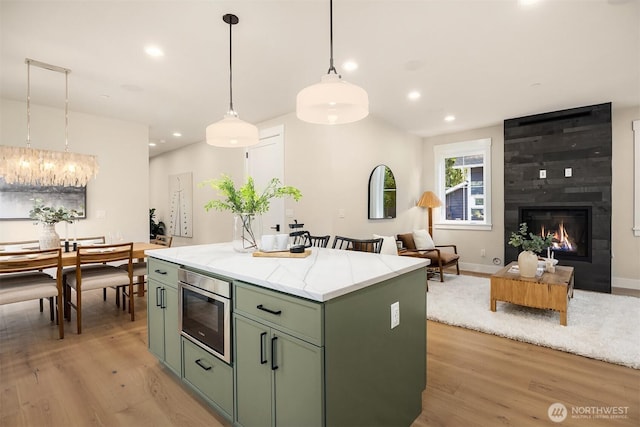 10511 NE 112th St, Kirkland, WA 98033 - kitchen with green cabinetry, light wood-style floors, a center island, stainless steel microwave, and recessed lighting