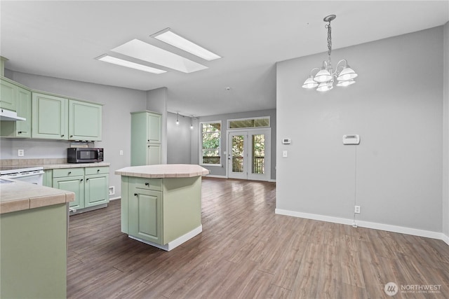 261 E Emerald Lake Dr W, Grapeview, WA 98546 - kitchen featuring stainless steel microwave, green cabinets, dark wood finished floors, and a kitchen island