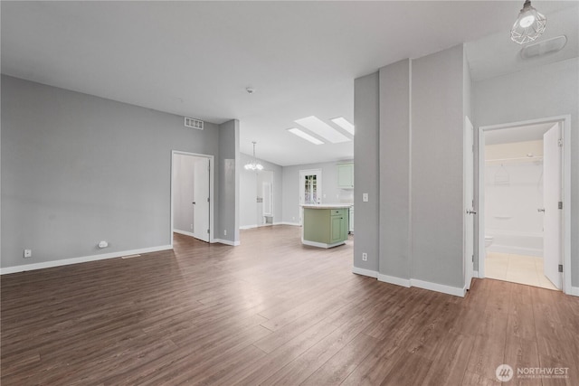 261 E Emerald Lake Dr W, Grapeview, WA 98546 - unfurnished living room featuring dark wood-style flooring, a chandelier, and a skylight