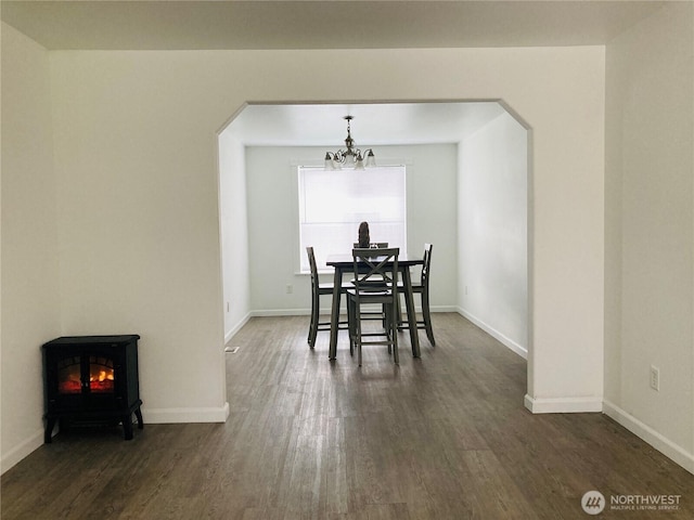 2020 Perch Ave, Moses Lake, WA 98837 - dining area with arched walkways, a chandelier, dark wood finished floors, and a wood stove