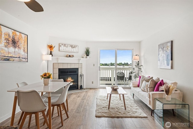 411 N 90th St Unit 406, Seattle, WA 98103 - living area featuring wood finished floors, a tiled fireplace, and ceiling fan