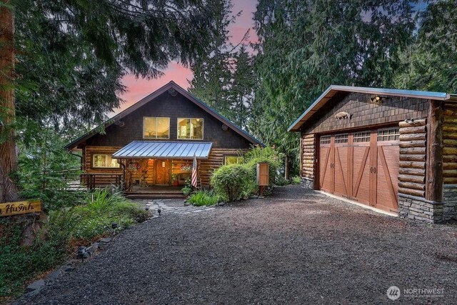 793 E Stadium Beach Rd W, Grapeview, WA 98546 - view of front of house featuring log exterior, dirt driveway, a standing seam roof, a porch, and a metal roof
