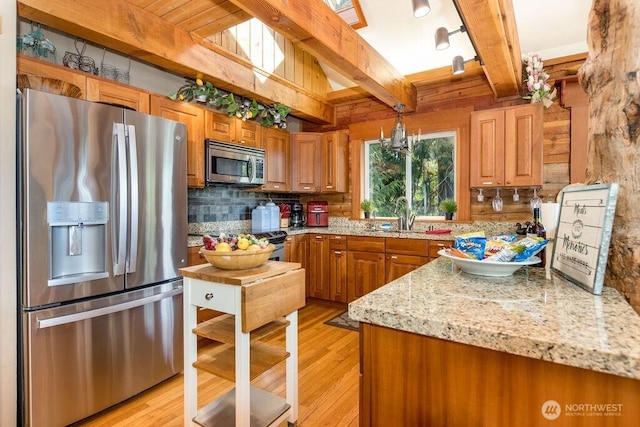 793 E Stadium Beach Rd W, Grapeview, WA 98546 - kitchen featuring stainless steel appliances, beam ceiling, tasteful backsplash, brown cabinetry, and light wood-style flooring