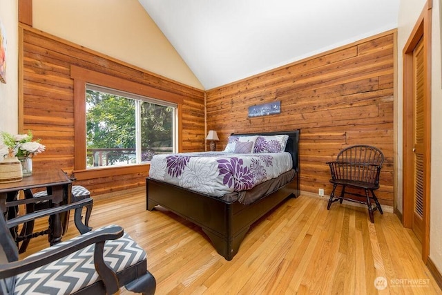 793 E Stadium Beach Rd W, Grapeview, WA 98546 - bedroom featuring light wood finished floors, high vaulted ceiling, and wooden walls