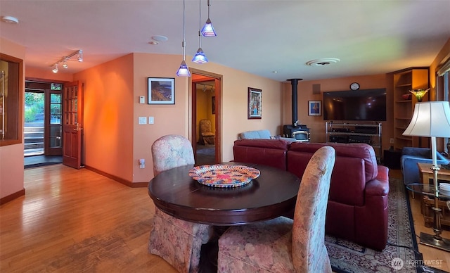 755 Ferry Rd, Lopez Island, WA 98261 - dining area featuring a wood stove, wood finished floors, and rail lighting