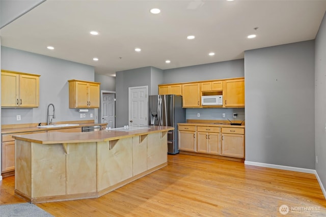 321 Range View Rd, Ellensburg, WA 98926 - kitchen with stainless steel appliances, light brown cabinetry, a kitchen island, light wood-style floors, and recessed lighting