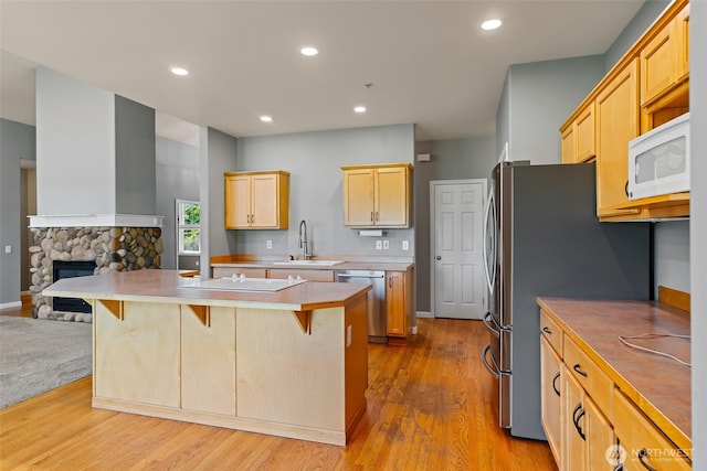 321 Range View Rd, Ellensburg, WA 98926 - kitchen with appliances with stainless steel finishes, a breakfast bar area, open floor plan, wood finished floors, and a kitchen island