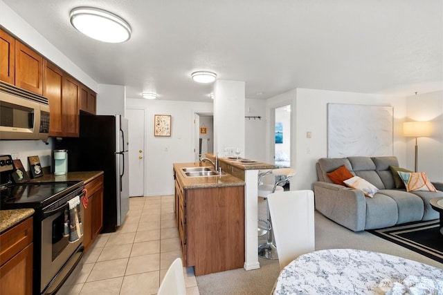 300 10th Ave Unit B310, Seattle, WA 98122 - kitchen featuring appliances with stainless steel finishes, open floor plan, brown cabinets, light tile patterned floors, and dark countertops