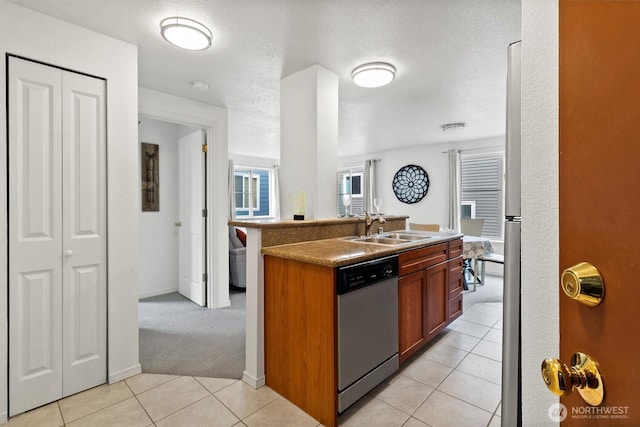 300 10th Ave Unit B310, Seattle, WA 98122 - kitchen featuring dishwasher, light tile patterned floors, a center island with sink, brown cabinets, and light carpet