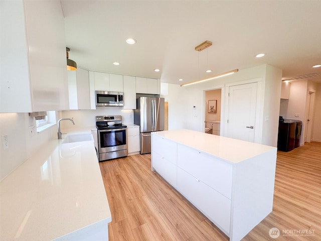 200 W Oak St, Yacolt, WA 98675 - kitchen featuring appliances with stainless steel finishes, modern cabinets, white cabinets, a center island, and light countertops