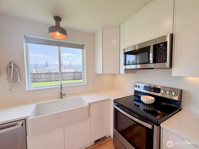 200 W Oak St, Yacolt, WA 98675 - kitchen featuring appliances with stainless steel finishes, white cabinetry, and light countertops