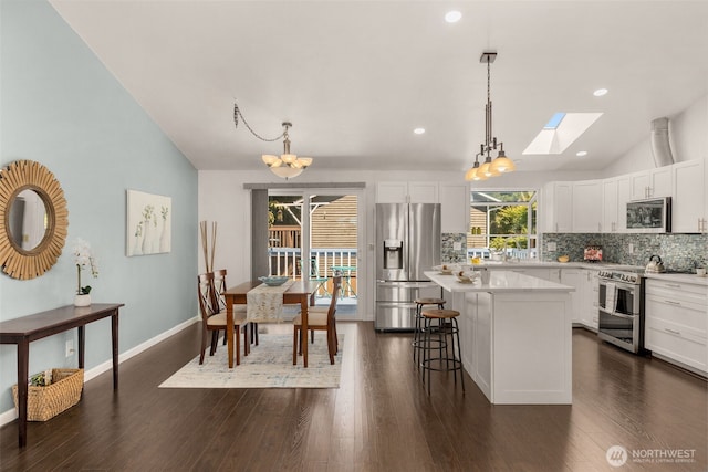 35404 18th Ave SW, Federal Way, WA 99023 - kitchen with stainless steel appliances, lofted ceiling, a skylight, a center island, and tasteful backsplash